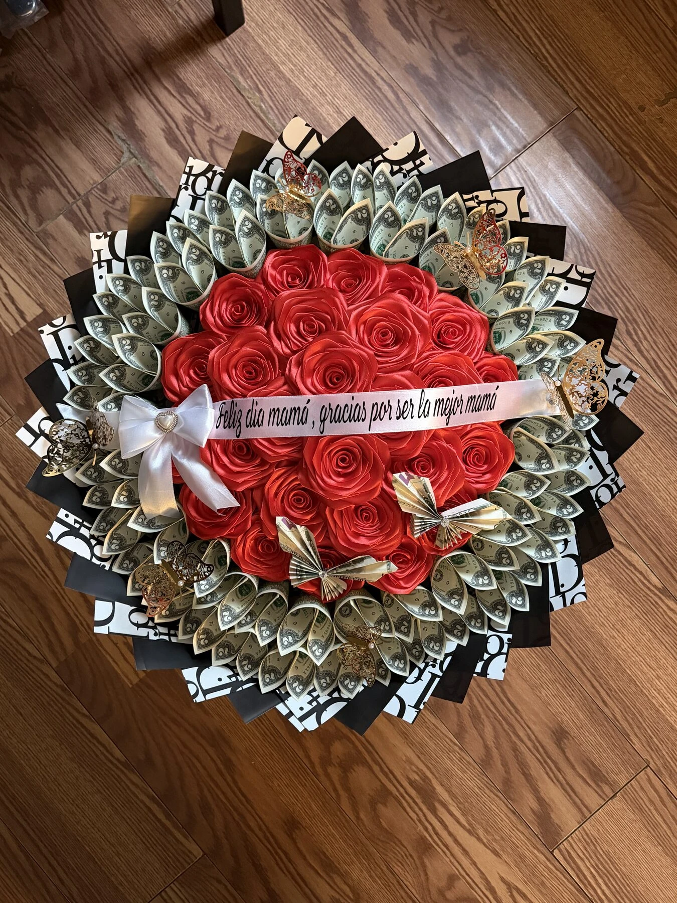 Flores rojas con billetes doblados y envoltura blanca y negra.